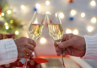 Two people's hands toasting with sparkle wine glass celebrating Christmas holidays. Happiness and love. Merry Christmas and happy new year