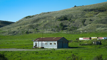 Fototapeta na wymiar Abandoned barn in green hills