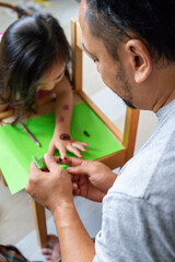 Painting henna ornaments on daughter's hand.