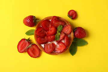 Delicious strawberry tart on yellow background, top view