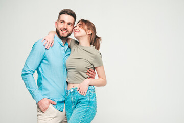 Naklejka premium Smiling beautiful woman and her handsome boyfriend. Happy cheerful family having tender moments on grey background in studio.Pure cheerful models hugging.Embracing each other