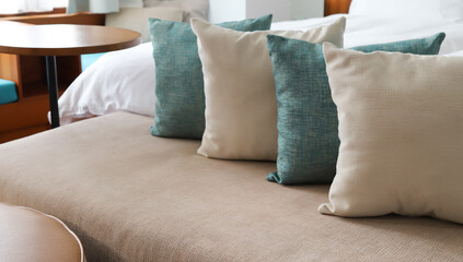 Closeup of soft brown and green couch  cushions on sofa in bedroom with outside sunlight. 