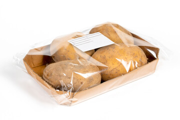 Freshly harvested potatoes in a labeled pack on white background