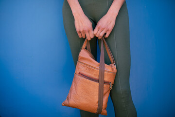 Cropped shot of woman holding leather bag