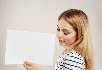 Naklejka premium blonde in a striped t-shirt white sheet of paper