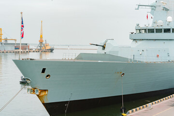 Nose of British warship with gun cannon moored to the coast. Conflict. Weapon. Ship. Vessel. Flag © AndriiKoval
