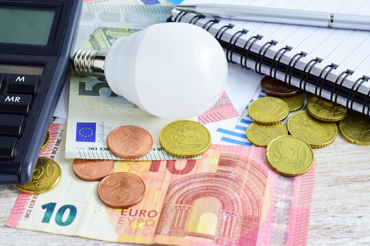 Electricity and energy tax expenses. Lightbulb, scattered money, euros, consumption graph, calculator. Economic concept.