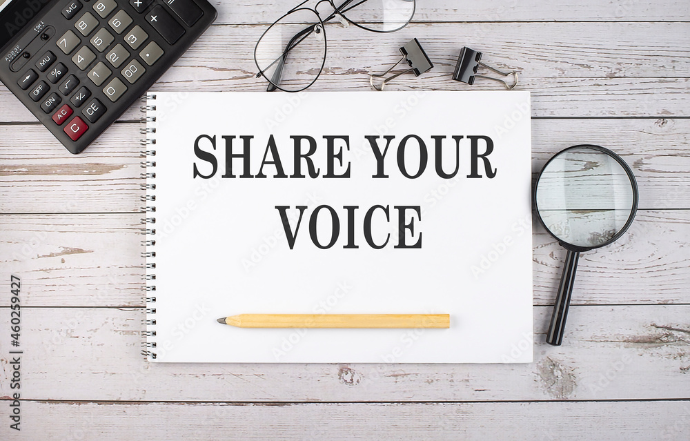 Aufkleber blank notebook with text share your voice on white background with calculator and office tools.