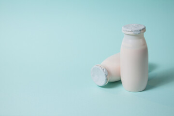 Bottles with probiotics and prebiotics dairy drink on light blue background. Bio yogurt with useful...
