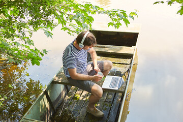 Mann arbeitet am Laptop im Sommer Urlaub am See