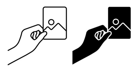 Linear icon. Hand holds paper photograph. Memories of vacation or trip to nature. Printing photos. Simple black and white vector isolated on white background