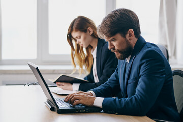 business man and woman in the office in front of a laptop career network professionals