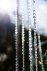 Glass, plastic, transparent beads in the form of crystals hang as decorations on the holiday...