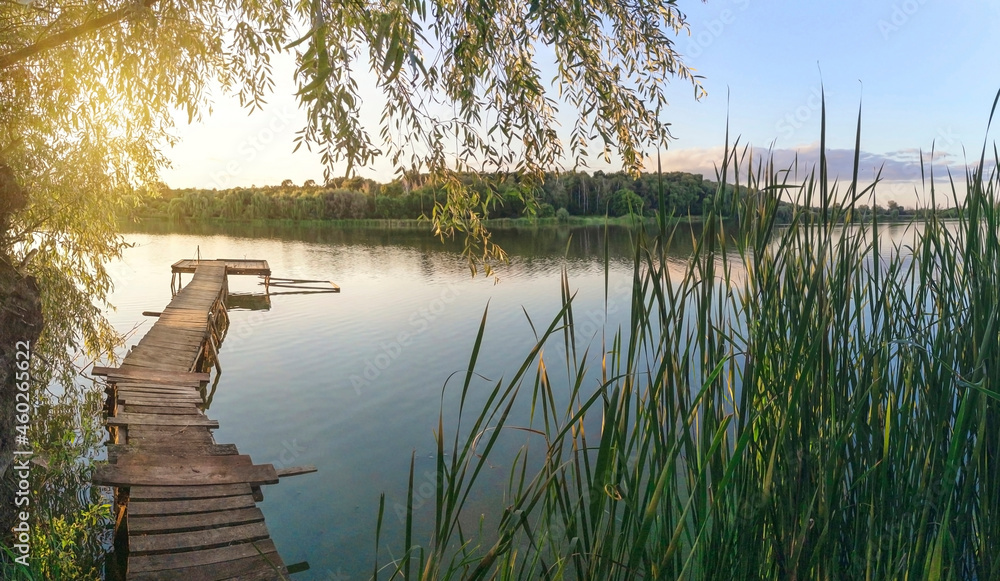 Wall mural lake panorama with fishing pier at sunset