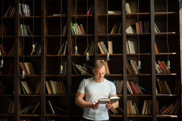 young man reading a book in the library 