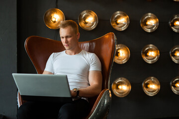 Caucasian male sitting with laptop indoors 