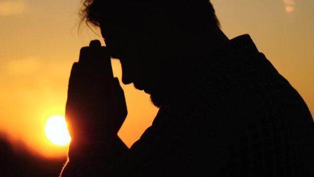 man prays at sunset in the sky, religious belief, the life of a believer, ramadan in the rays of the light of the sun, ask for forgiveness from the sky, read prayer in glare of sun, believe in dream
