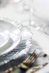 Festive white plates on the table. Close-up. A glass plate with a grooved edge.