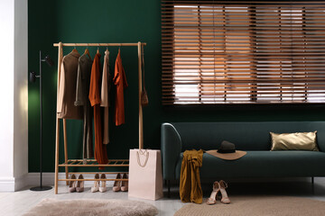 Modern dressing room interior with clothing rack and comfortable sofa