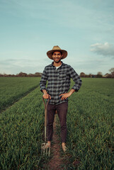 Naklejka na ściany i meble Mixed race male farmer standing in lush green fields