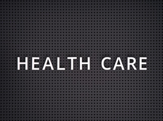Words Health Care spelled out with white letters on gray pegboard