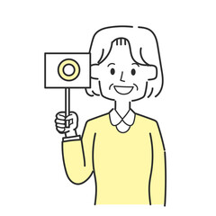 丸が書かれた札を持っているおばあさん
