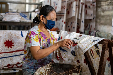 A batik craftsman is making batik. Batik is one of Indonesia's cultural heritage which has become...