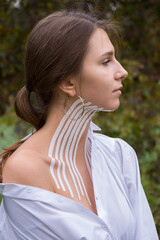 Fototapeta premium Face and body taping. A special cosmetic procedure for the skin. Beautiful young girl in autumn on the nature