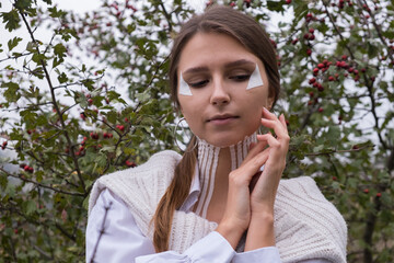 Face and body taping. A special cosmetic procedure for the skin. Beautiful young girl in autumn on the nature