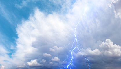 Lightning strikes between stormy clouds.