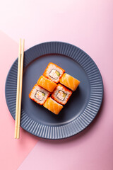 Traditional Japanese food Philadelphia sushi on a modern pink background, minimalistic concept
