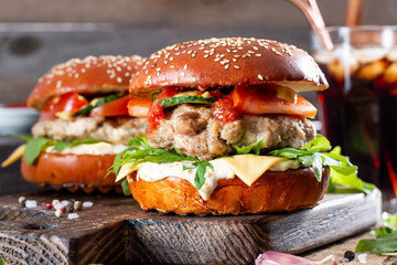 Homemade juicy burgers with beef, cheese and arugula on a table. American cuisine. Fast food