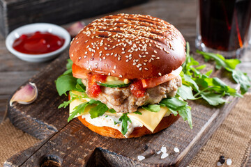 Homemade juicy burgers with beef, cheese and arugula on a table. American cuisine. Fast food