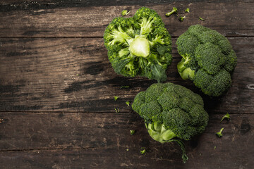 Green fresh broccoli on old wooden background. Ripe vegetables for diet and healthy eating