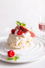 Beautiful meringue roll named Pavlova, decorated with figs and raspberries