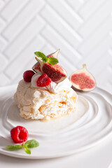 Beautiful meringue roll named Pavlova, decorated with figs and raspberries