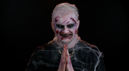 Sly cunning sinister one man in costume of Halloween crazy zombie with bloody wounded scars face...