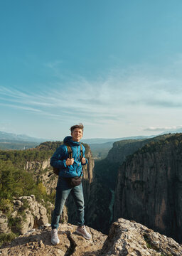 Vertical image tourist man standing on cliff of Tazi Canyon in Turkey, enjoying beautiful panoramic nature view