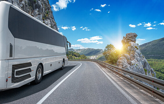 White passenger bus on the highway against the backdrop of a beautiful landscape.