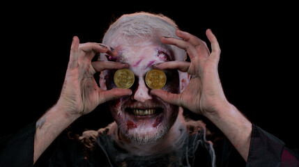 Zombie man with make-up with fake wounds scars showing golden bitcoins. Achievement career wealth,...