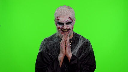Sneaky zombie man alone with makeup with wounds scars with tricky face gesticulating and scheming...