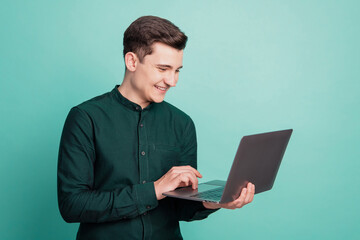 Portrait of cheerful happy worker man hold netbook shiny white smile on turquoise background