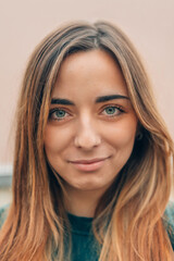 Fototapeta premium close up portrait of natural beauty caucasian young woman with long light brown hair and green eyes hinting at a sly smile