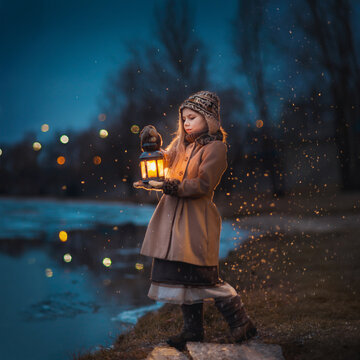 Little girl in retro stylish coat and hat standing near the river with lantern in the evening. Fairytale atmosphere