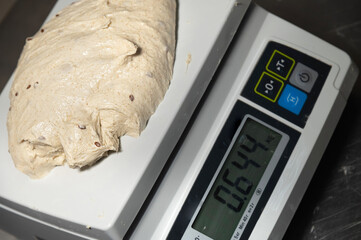 Close-up of weighing dough before baking bread. Craft bakery. Fast Professional Work of Bakers