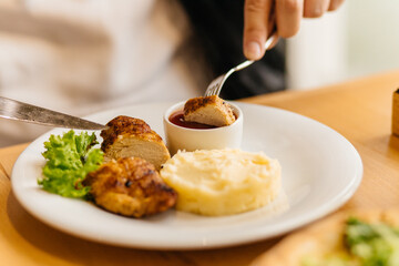 man eats potatoes with chicken steak