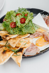 fresh breakfast on a plate. Bread, lettuce, egg with bacon