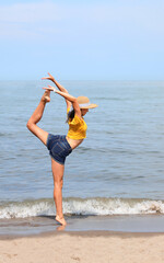 young skinny girl with straw hat and yellow t-shirt performs a gymnastic exercise called ECART
