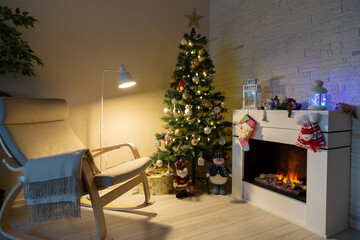 Decorated Christmas tree, gifts in boxes, a Santa Claus statuette, a burning fireplace. New Year, Christmas. Selective focus.
