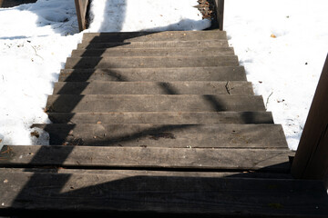 Wooden staircase to the hill in the snow.